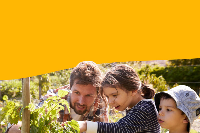 Thriving Regions Fund, an adult and two children in a garden tending to a plant.