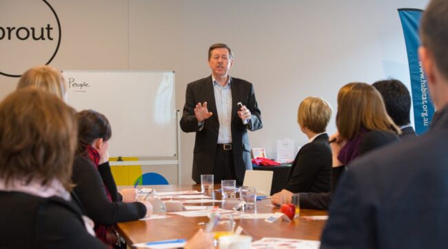 Peter Daniels addresses a board room.