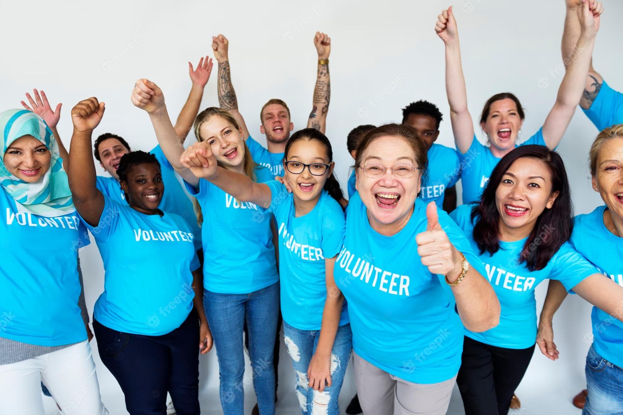 A group of people cheering in blue Volunteer T shirts