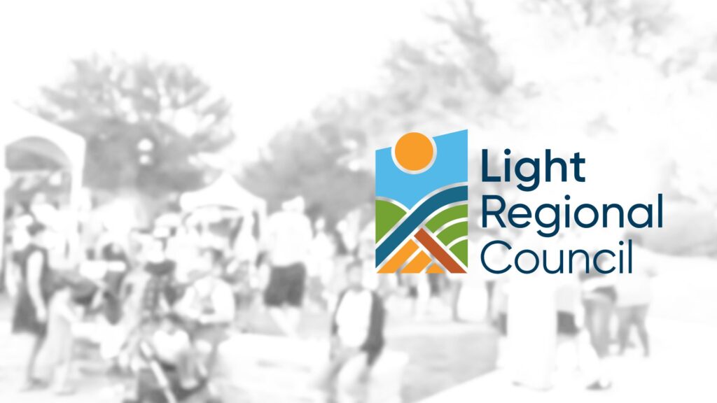A black and white community event blurred with the Light Regional Council logo in front.